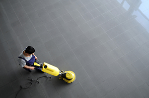 A technician waxes and buffs an office building floor